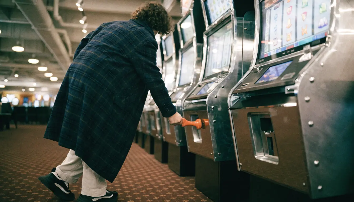 Person spielt an Spielautomaten, Fokus auf Walzen